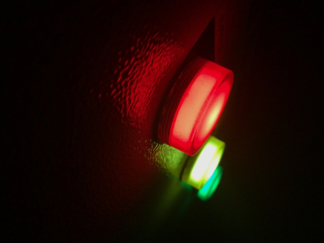 A red alarm beacon glowing on a dark wall at night