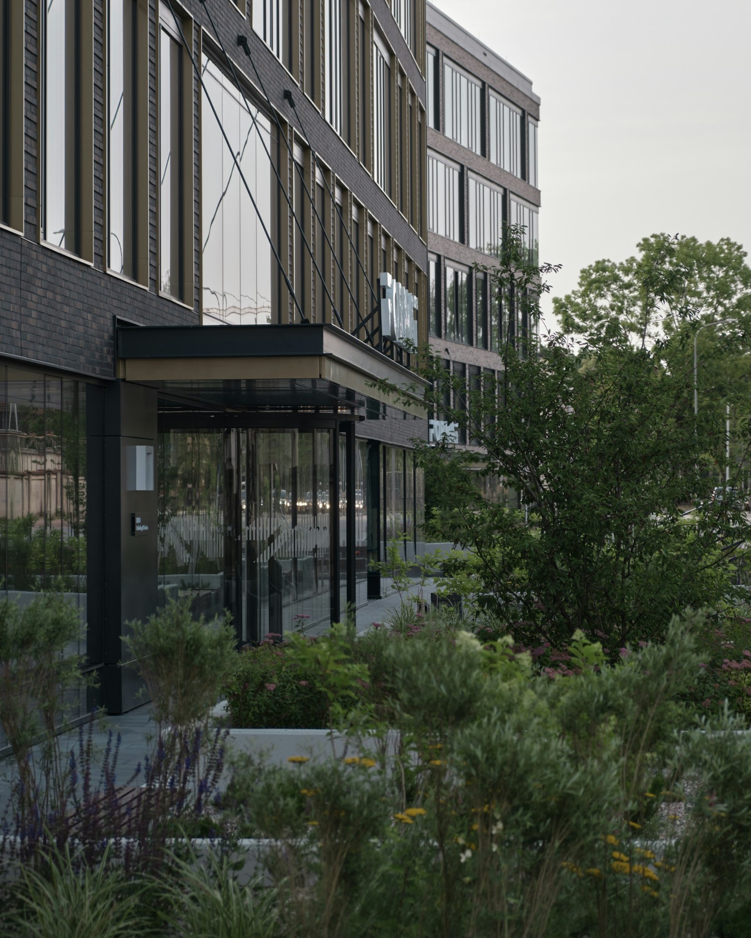 Modern office building exterior with landscaped entrance